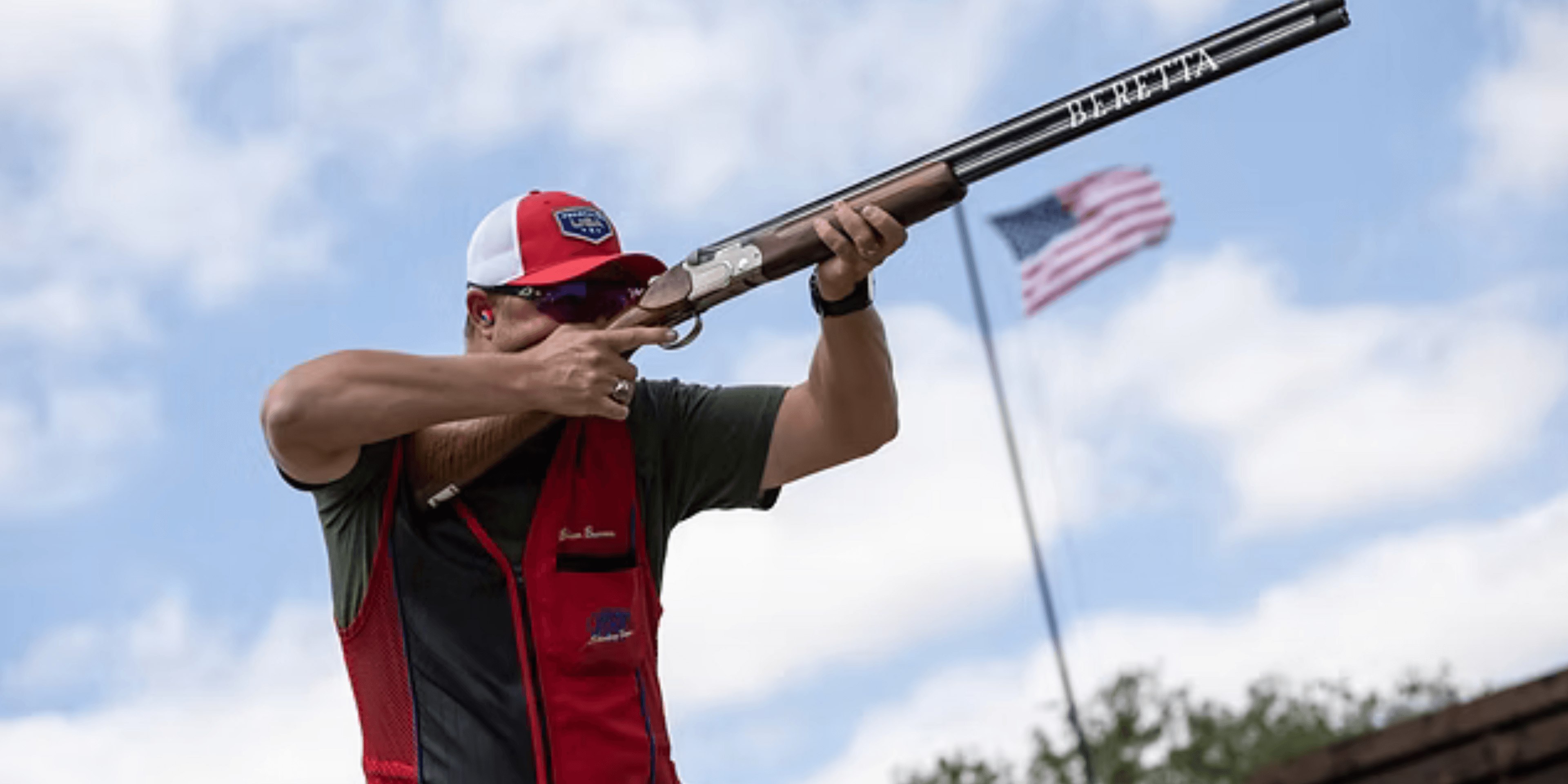 Brian Burrows competing in Olympic trap shooting with American flag in background
